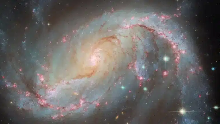 O telescópio espacial Hubble captura uma galáxia espiral com uma infinidade de luzes diferentes e chamativas