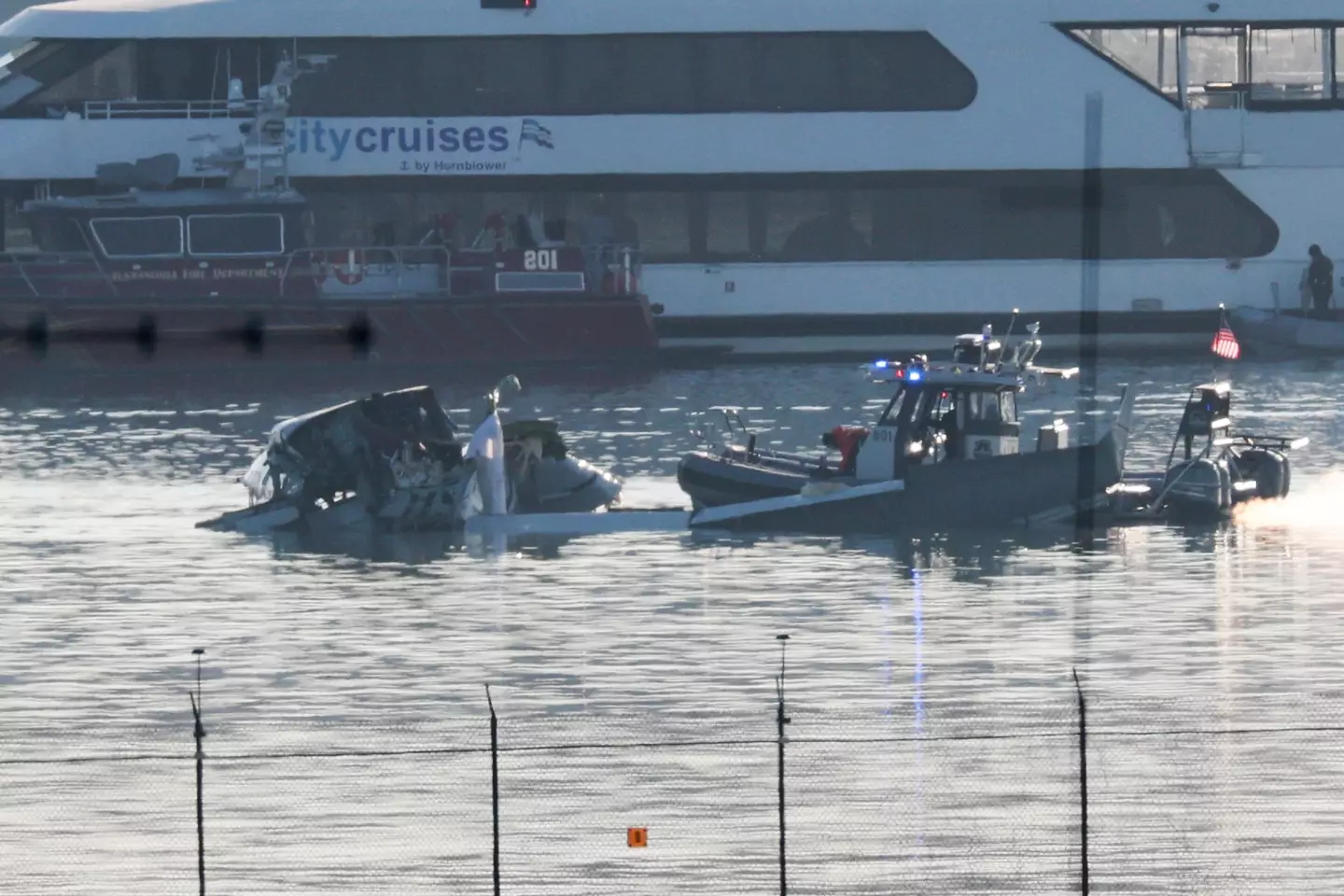 Unidades de resposta de emergência vasculham o local do acidente do avião da American Airlines no rio Potomac.